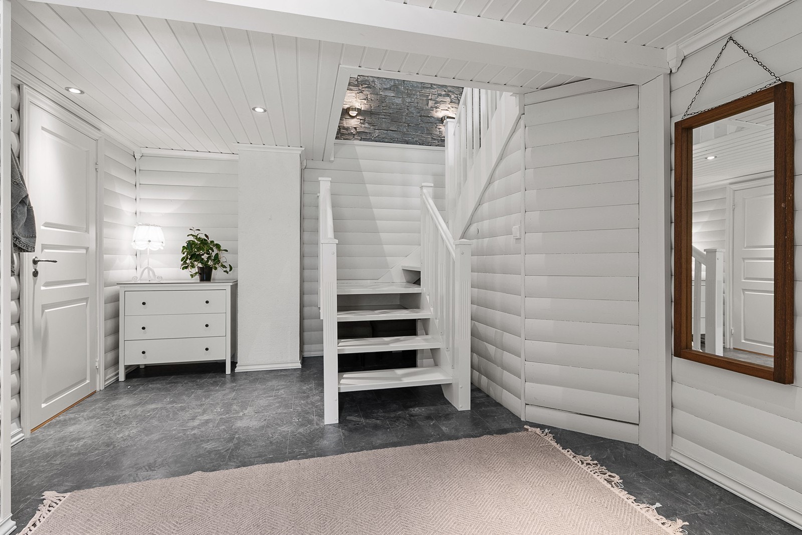 Man ønskes velkommen av en romslig entré med downlights og tilliggende bod. Galleribilde