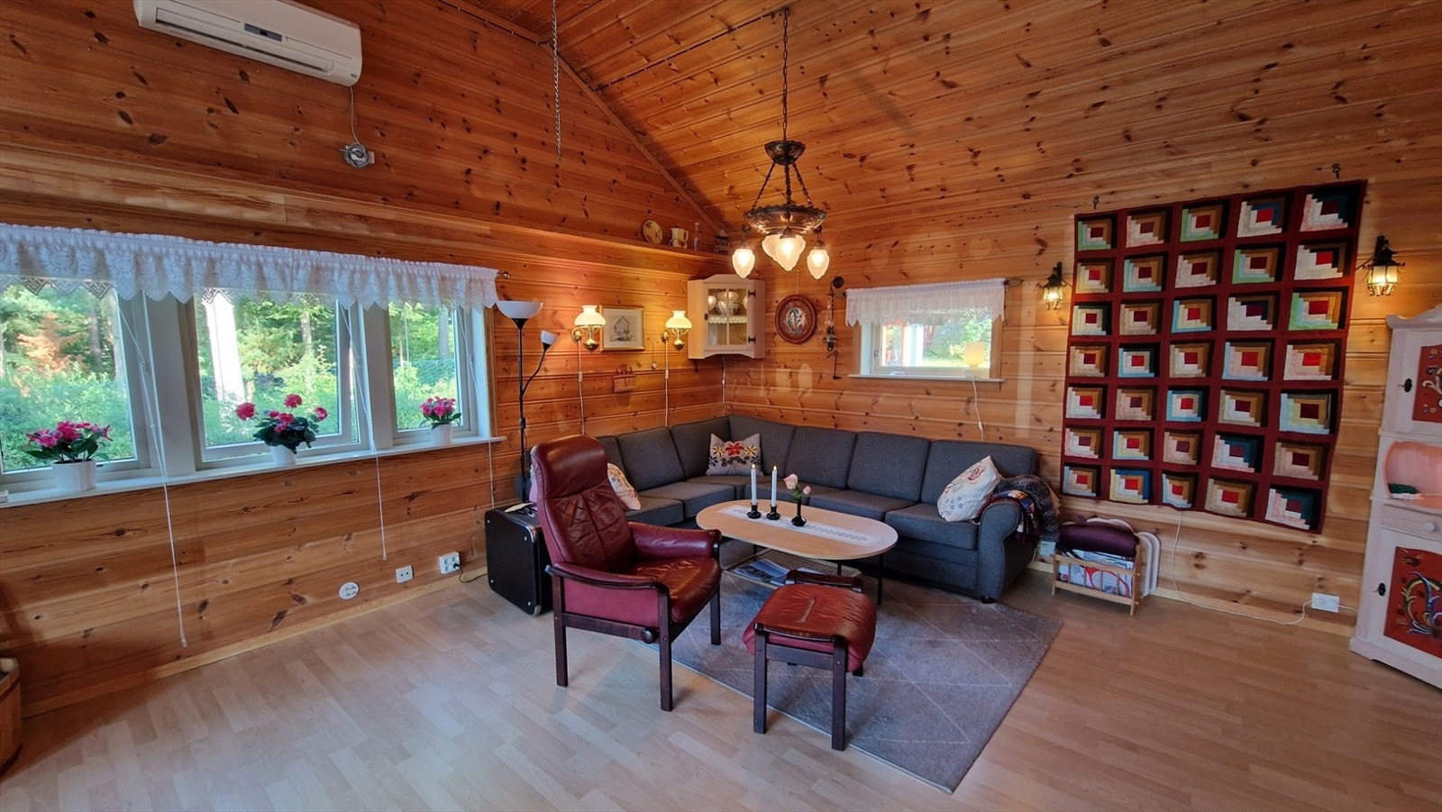 Det er panel på veggar og tak i stova. Laminat på golv. Galleribilde