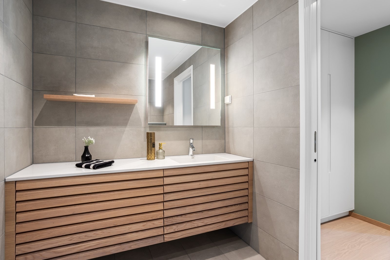 Baderommene er innredet med delikate og moderne fliser på gulv og vegger som tilbyr litt "hverdagsluksus". Begge baderommene er tonet i moderne grått - begge i typisk "spatema" med elegante fliser i matt-finish. Galleribilde