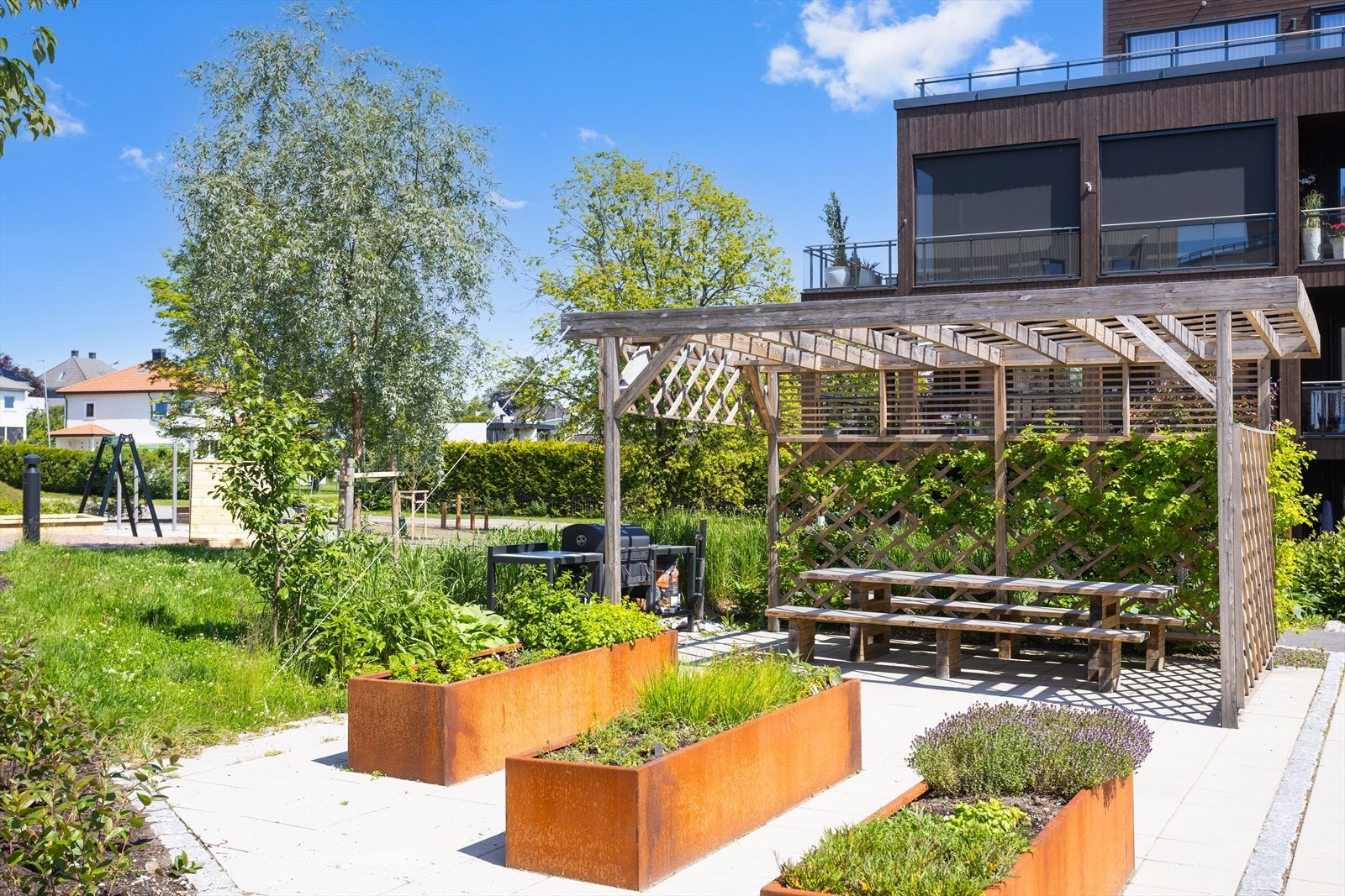 I felleshagen finner man soner med pergola, felles utegrill, sittegrupper ved sosiale treffsoner og pent tilpasset beplantning i den grønne parken som omkranser boligene. Galleribilde