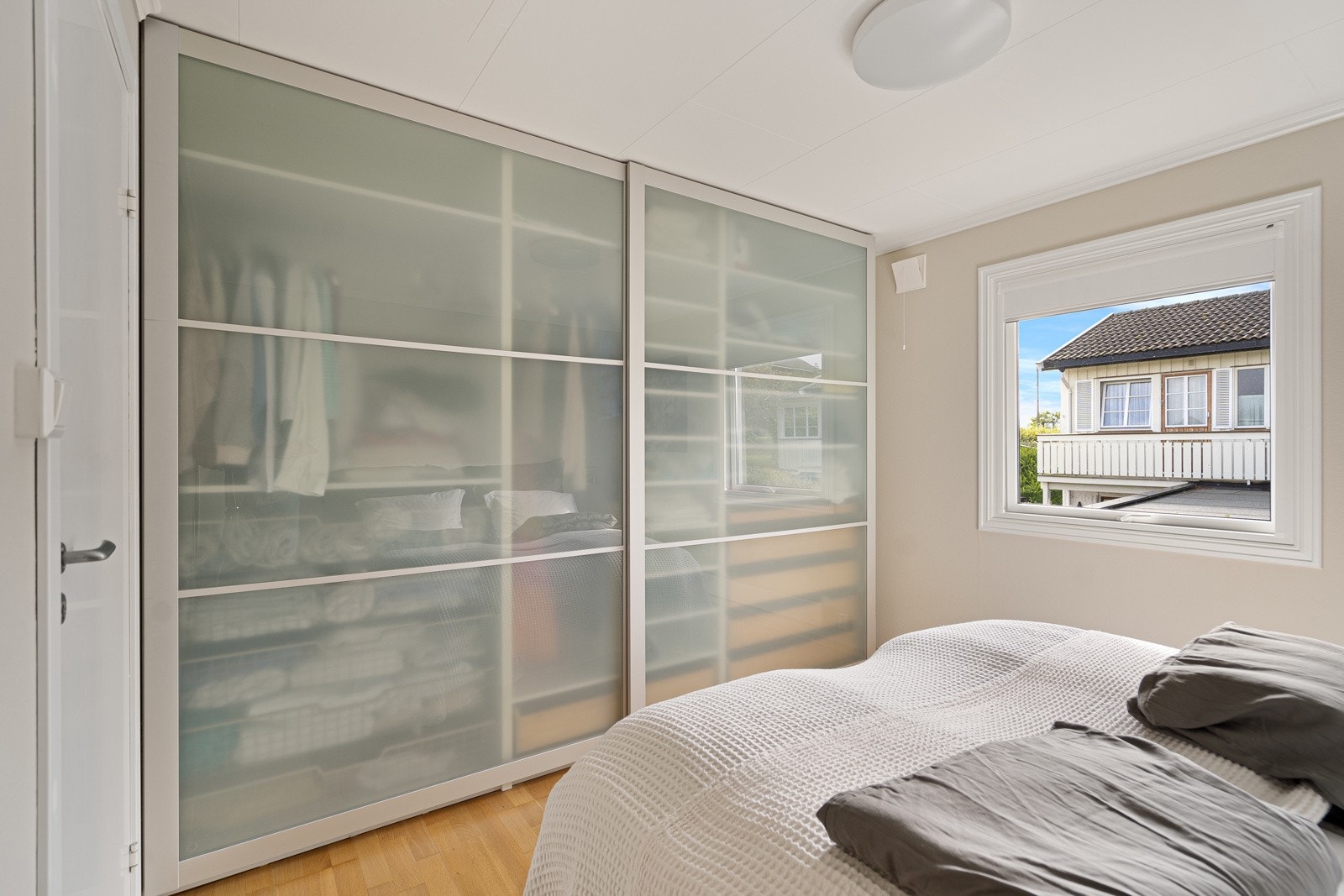 Romslig hovedsoverom med skyvedørsinnredning Galleribilde