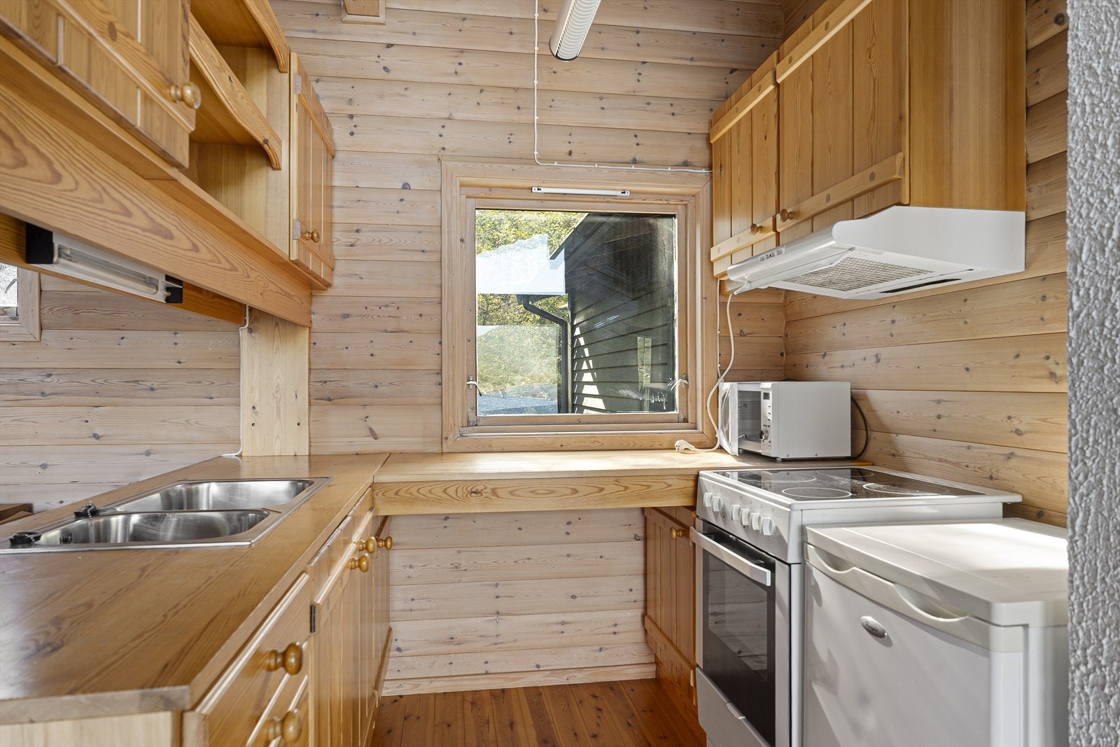 Plassbebygd, skikkelig kjøkken med profilerte fronter og heltre benkeplate. Medfølgende hvitevarer. Galleribilde