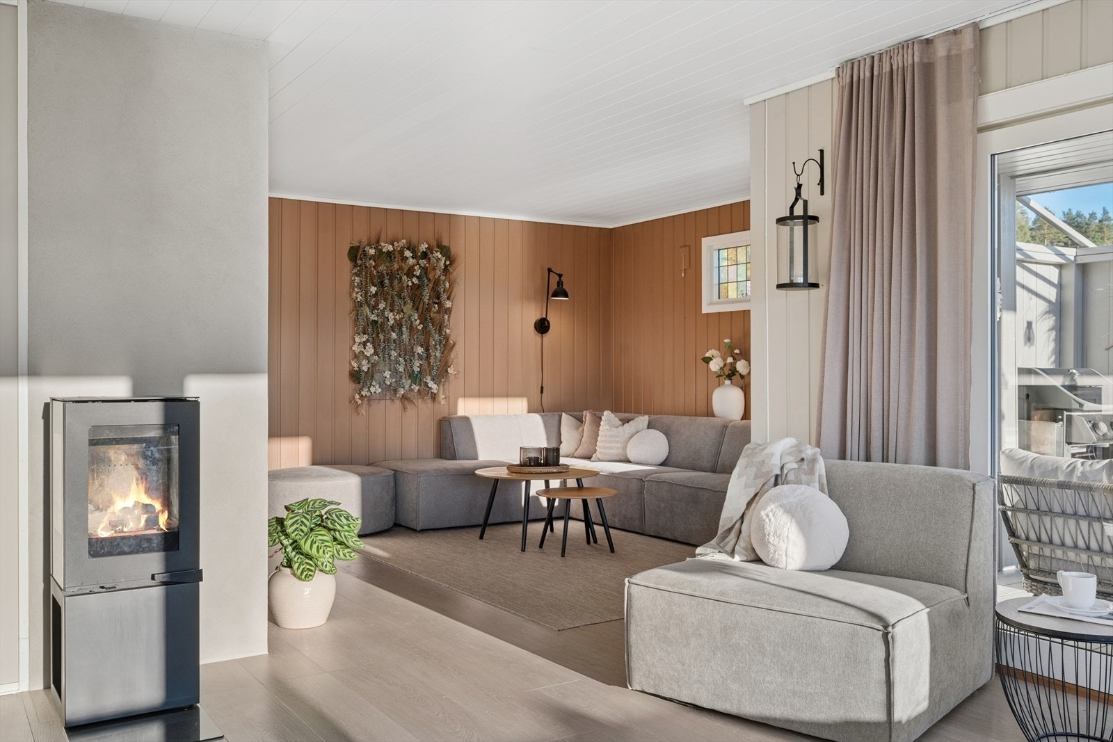 Sentralt i rommet finner vi et flott ildsted med vedovn som skaper en lun og behagelig stemning, samt sikrer god varme på kalde høst- og vinterkvelder. Det er i tillegg montert varmepumpe i trappegangen mot underetasjen. Galleribilde