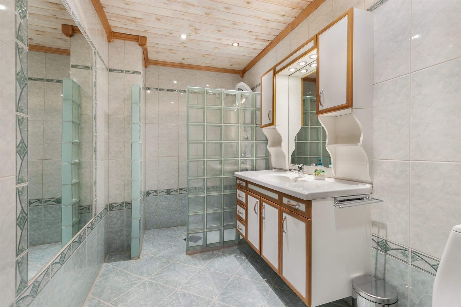 Baderommet er eldre og er gjennomført med flislagt gulv og vegger. Rommet er innredet med baderomsinnredning med servant og skuffe- og skapseksjon, med tilhørende speil og sideskap. Vi gjør oppmerksom på at bildet er tatt i regi av tidligere salg i 2020. Galleribilde