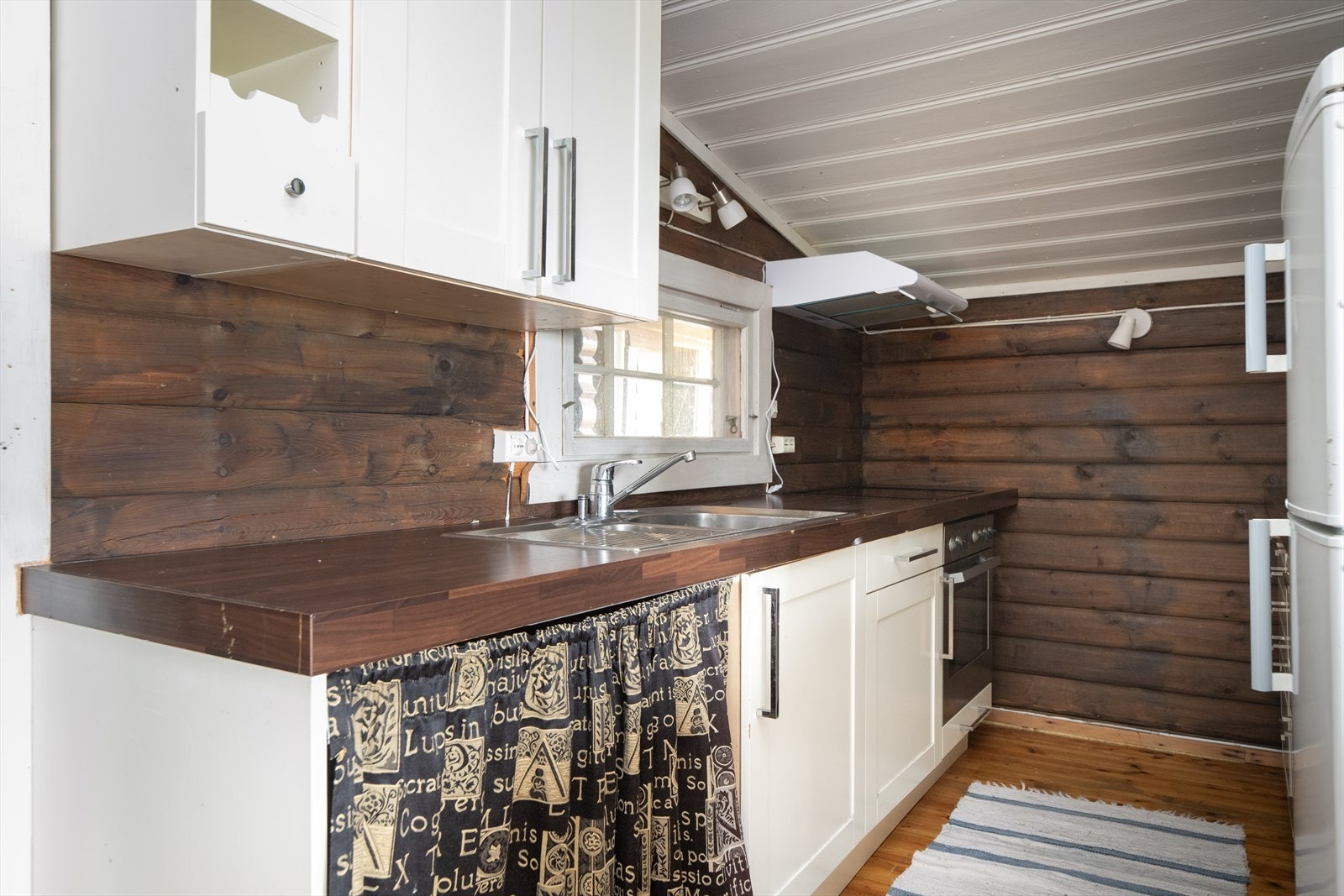 Kjøkkenet er utført i samme, varme fargetone som stua. Her er det kjøkkeninnredning fra IKEA, med innredning på to sider og plass til alt man måtte trenge på hytta. Galleribilde