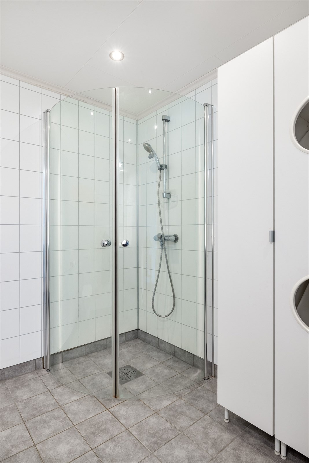 Baderommet er også utstyrt med dusjhjørne med innfellbare glassdører, veggmontert toalett og to ekstra høyskap. Galleribilde