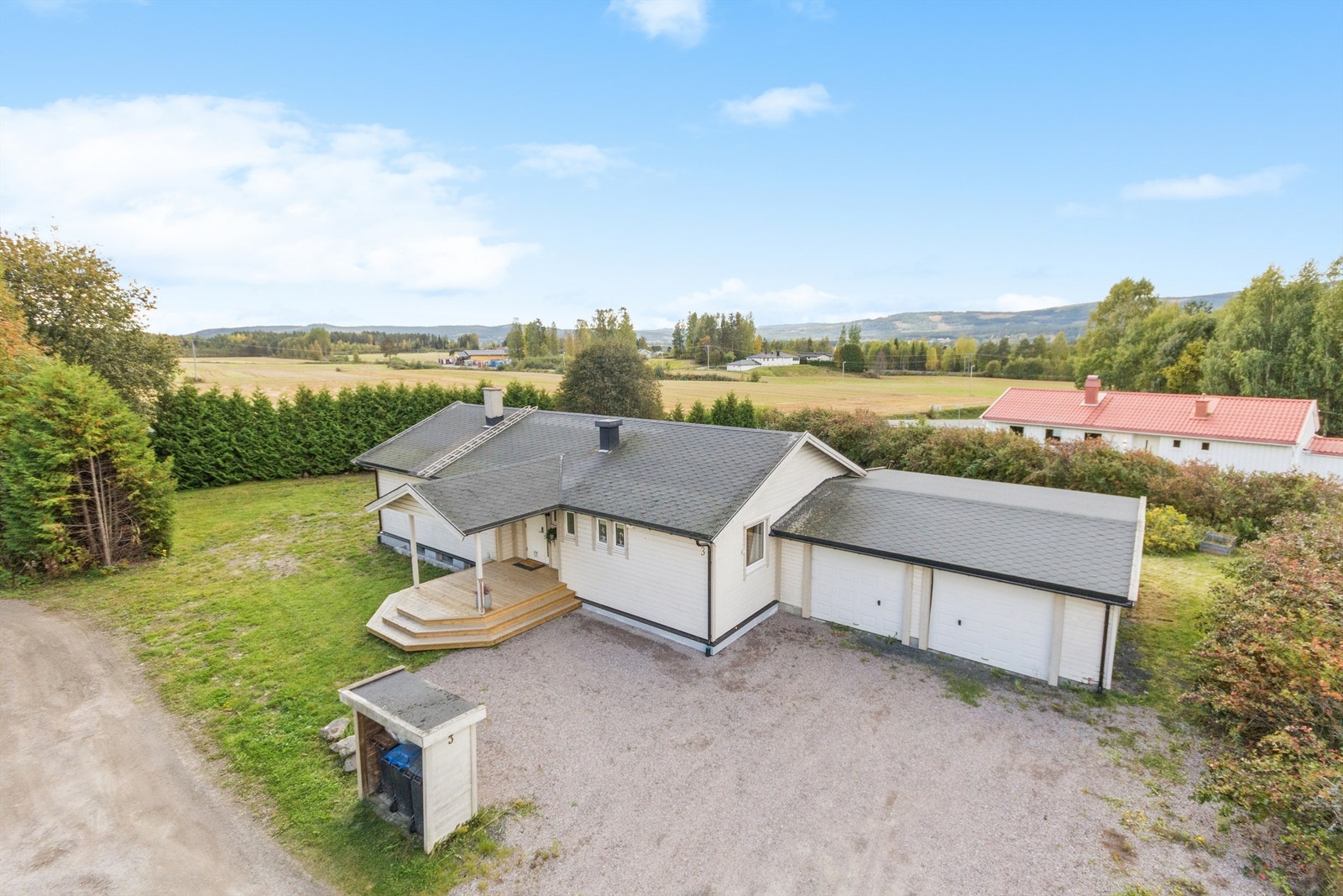 Eiendommen ligger i landlige omgivelser i Våler, med en stor, gruset gårdsplass og dobbelgarasje. Galleribilde