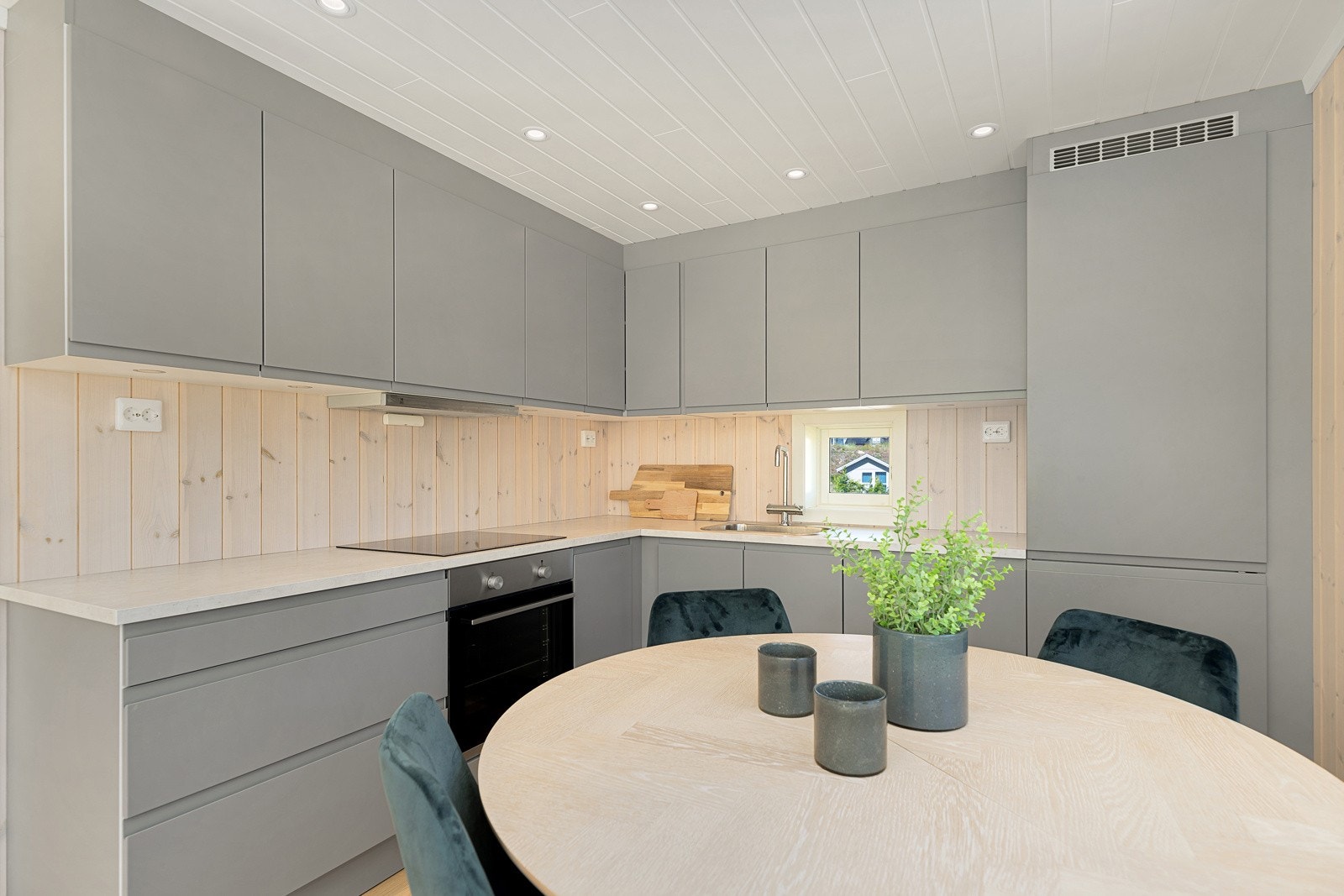 Pent kjøkken med integrert stekeovn, platetopp, oppvaskmaskin og kjøl/frys Galleribilde