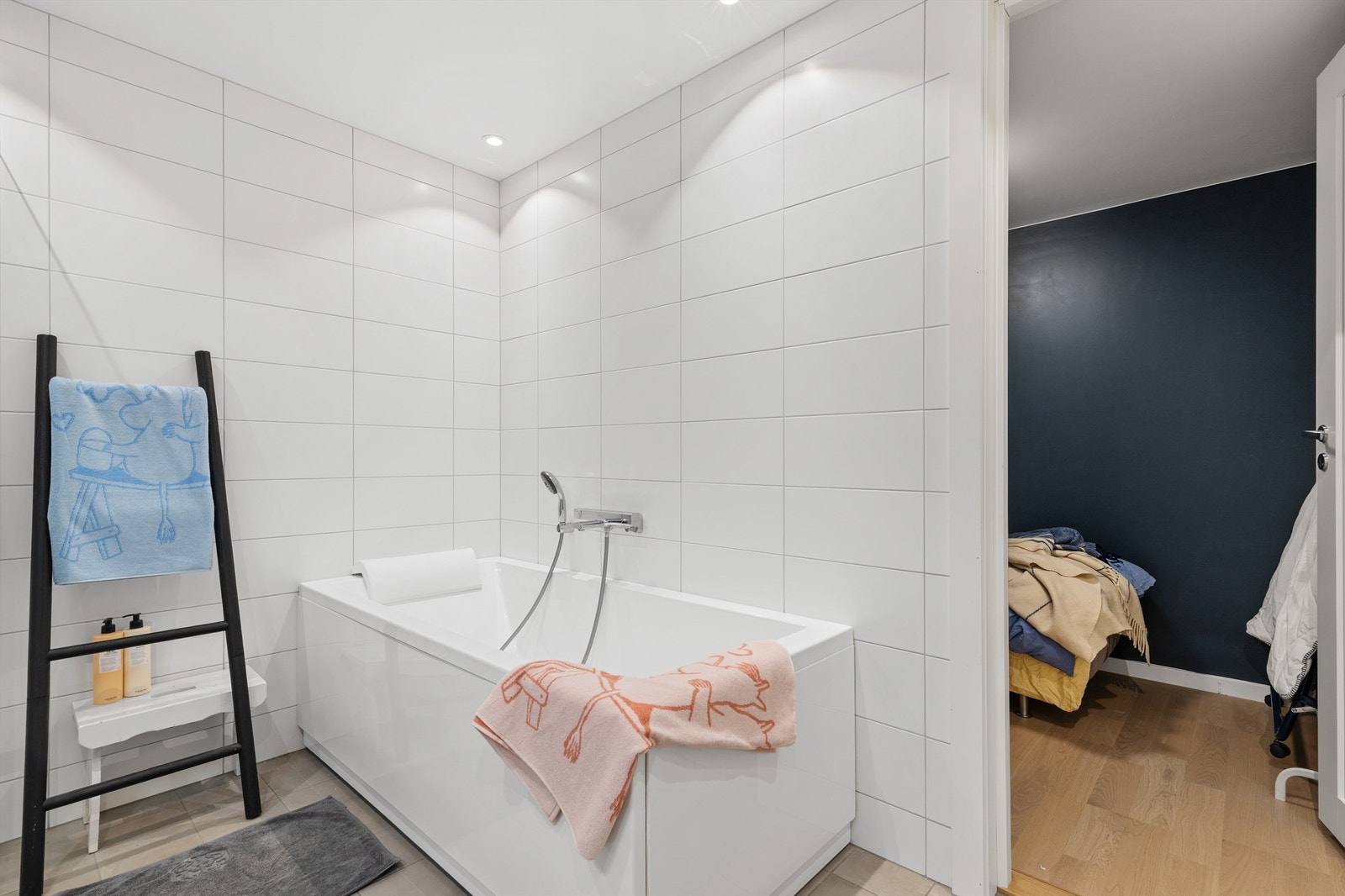 Bad 2 i 1.etasje ligger ved trimrommet. Fliser på vegger og gulv. Slett malt tak. Enkelservant med ett-greps armatur. Servantinnredning. Speilskap. Dusj med svingbare dusjdører. Vegghengt toalett. Badekar. Avtrekk tilkoblet balansert ventilasjonsanlegg. Galleribilde