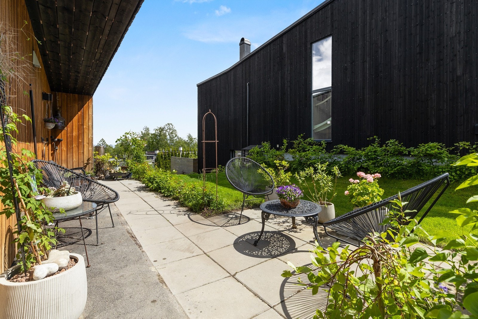 Inngangspartiet med koselig uteplass med plass til kafébord og stoler. Galleribilde