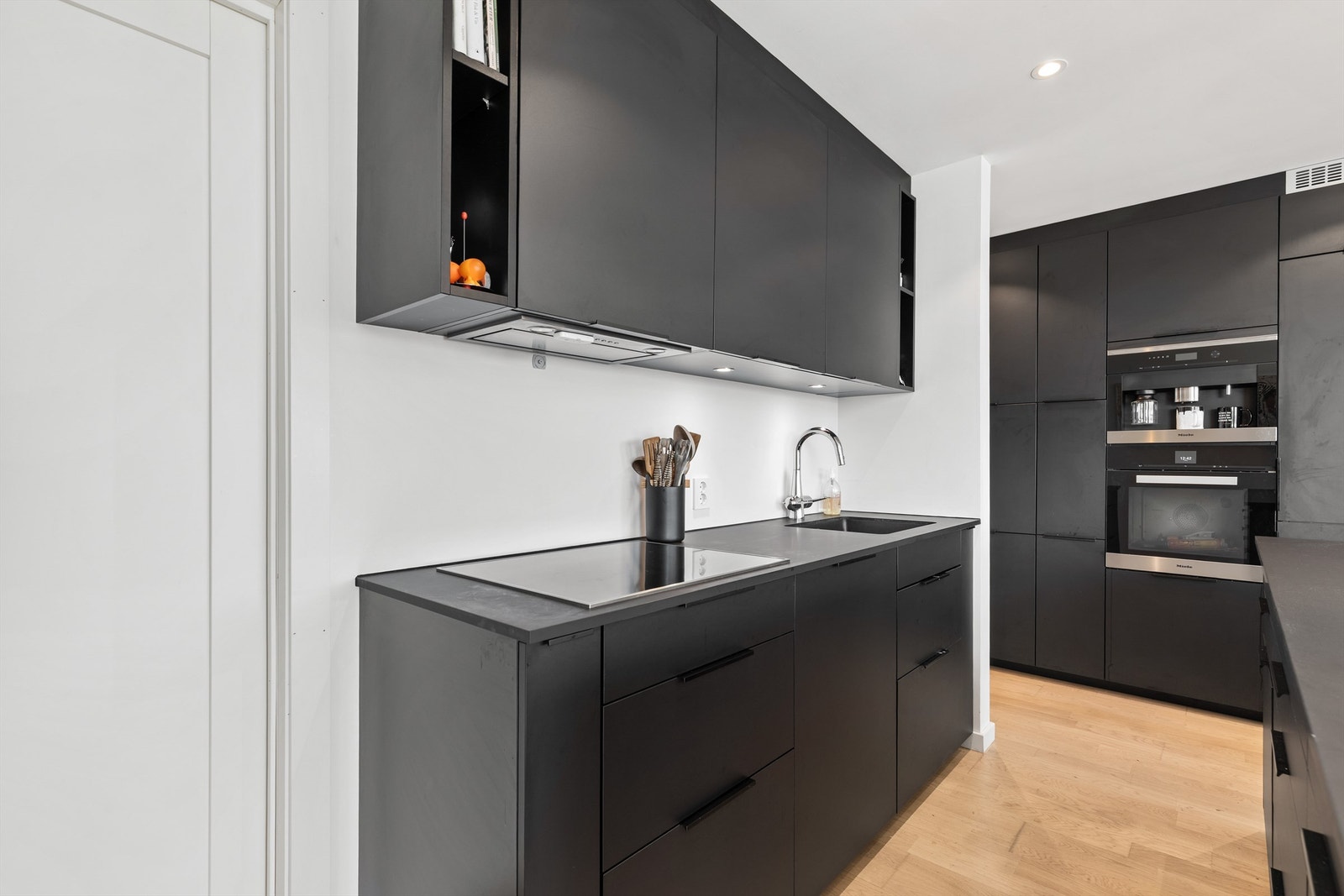 Kjøkken fra 2020 med kjøkkenøy. Slette fronter og og integrerte hvitevarer. Benkeplate av laminat. Ventilator tilkoblet avtrekkskanal. Galleribilde