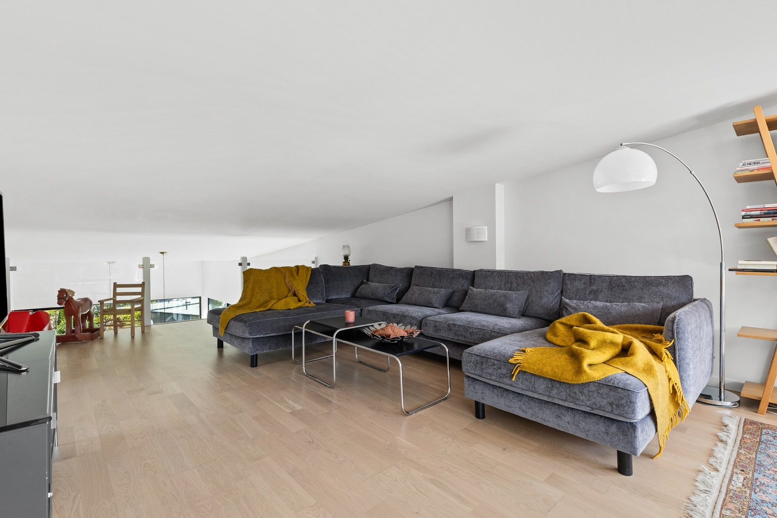 Fra entreen kommer man opp trappen til en stor loftstue. Her er det god plass til TV-område, skrivebord og sittegruppe. Galleribilde