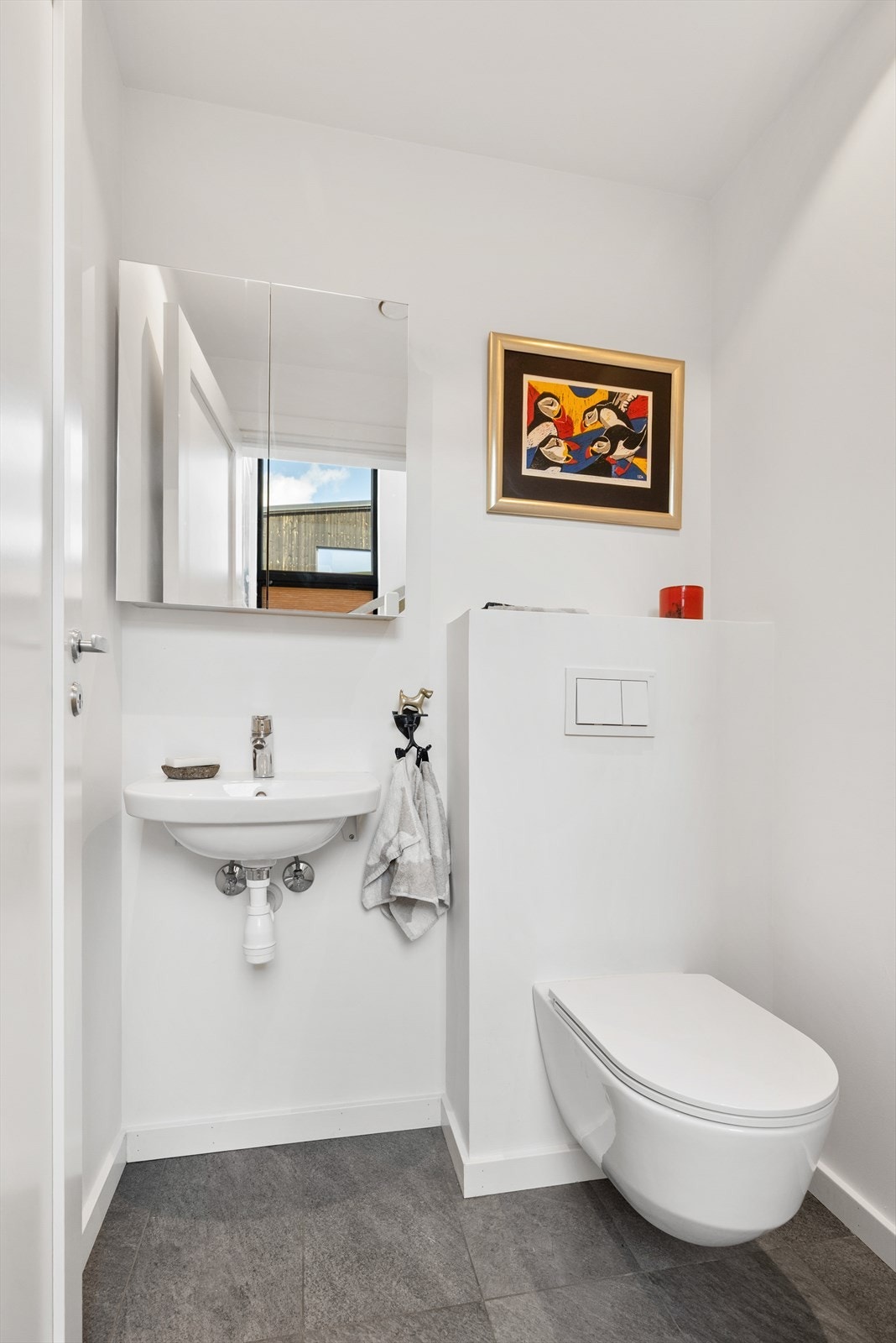 WC-rom med tilgang fra entreen. Vegghengt toalett og servant med overskap. Galleribilde