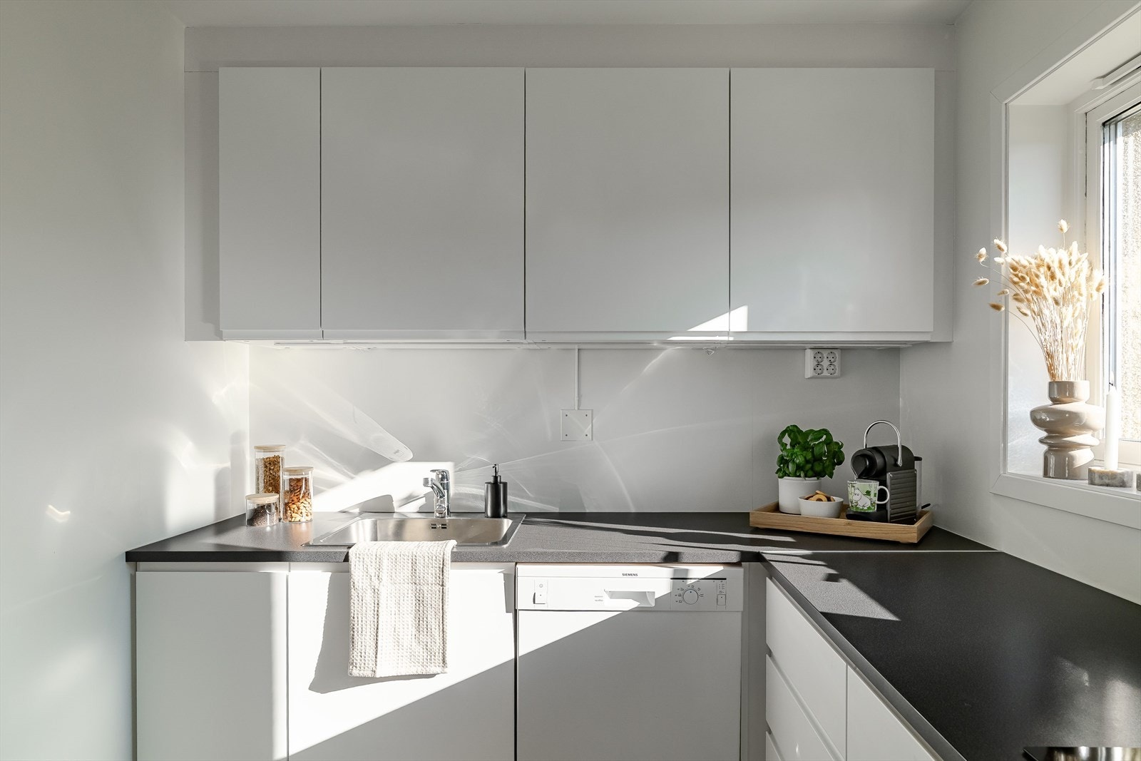 Stilrent kjøkken på 6 kvm, oppusset i 2019 med moderne løsninger. Malte fronter og laminert benkeplate gir et tidløst uttrykk. Galleribilde