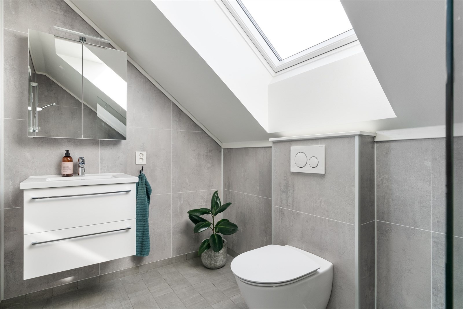 Badet er utstyrt med dusjhjørne, varmekabler og vegghengt toalett. Galleribilde