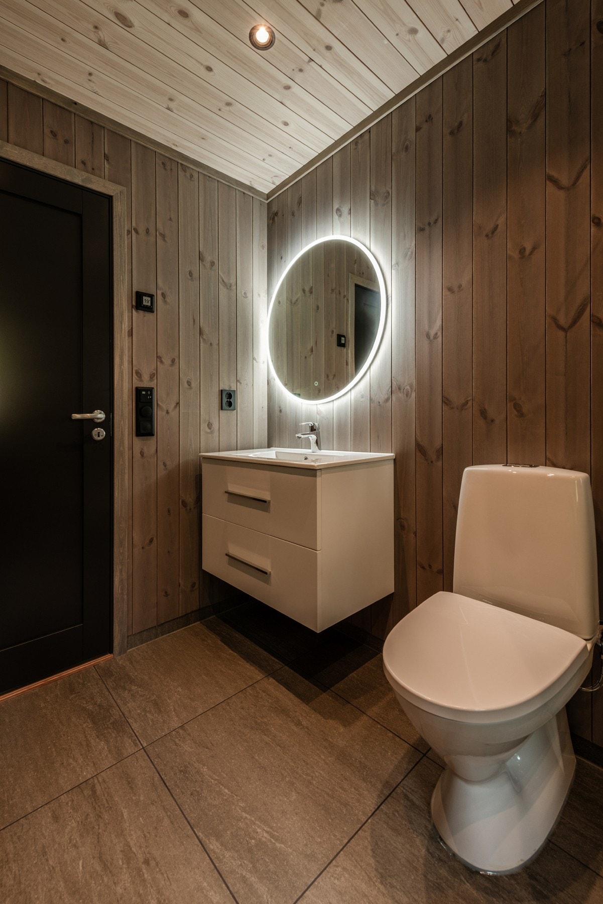 Badet er innredet med dusj, toalett og servant med innredning. Galleribilde