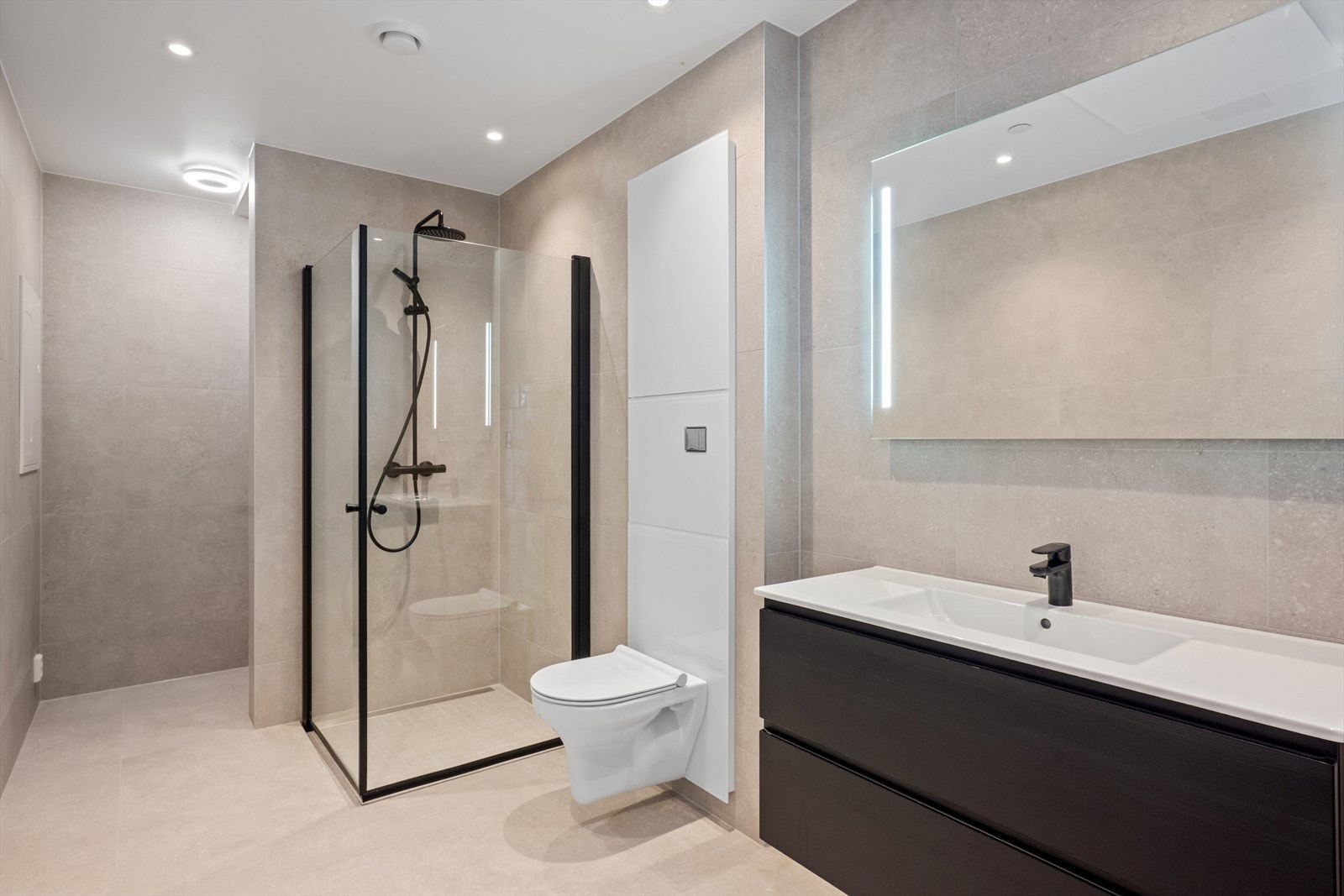 Helfliset baderom med avsatt plass til vaskemaskin bak skillevegg Galleribilde