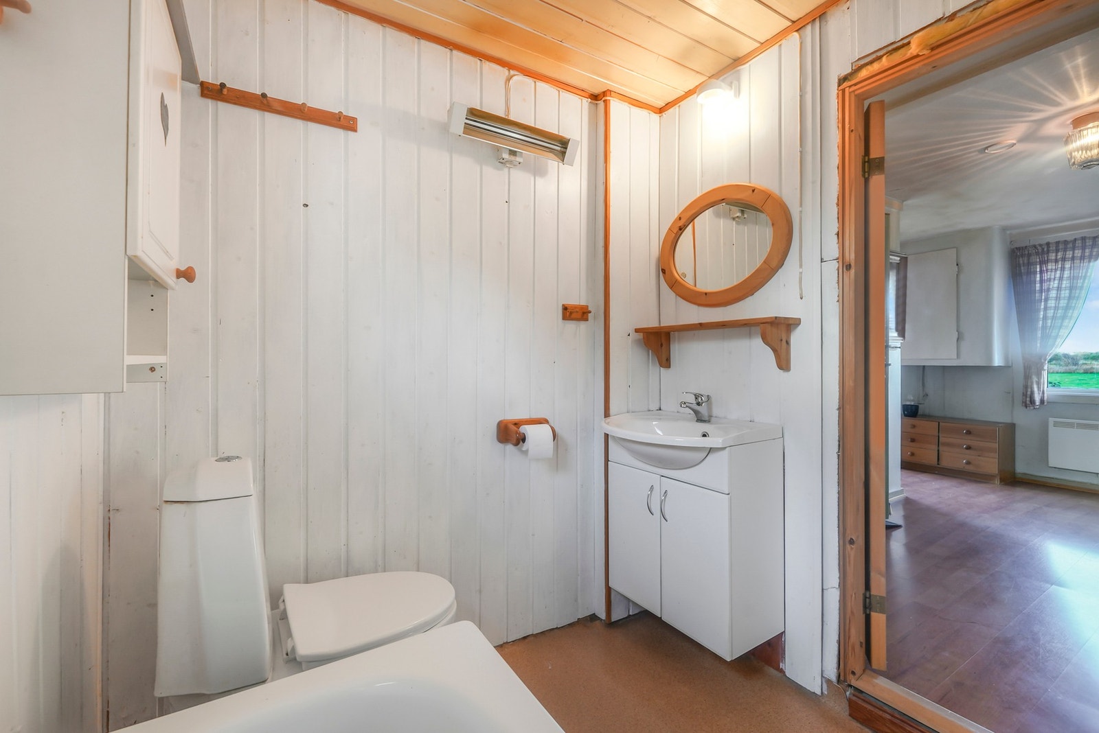 Eldre bad med servant, toalett, badekar og vaskemaskin/tørketrommel. Galleribilde