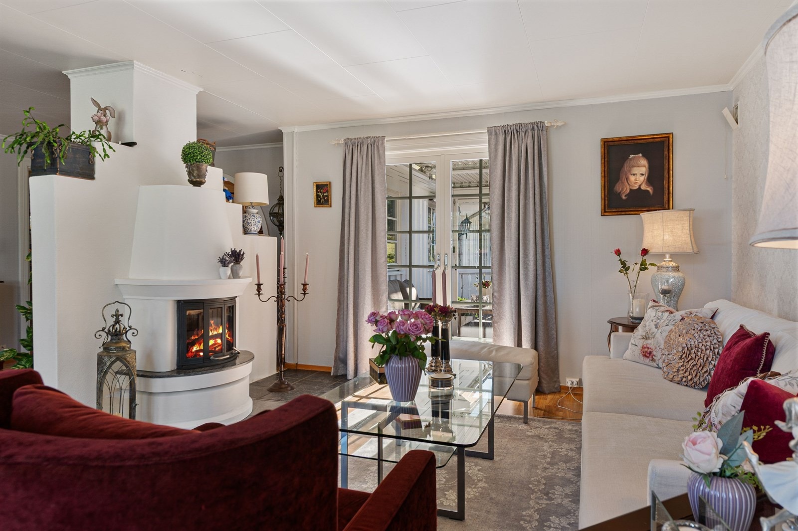 Stilig stue med peisovn som gir en lun atmosfære, og utgang til veranda. Galleribilde