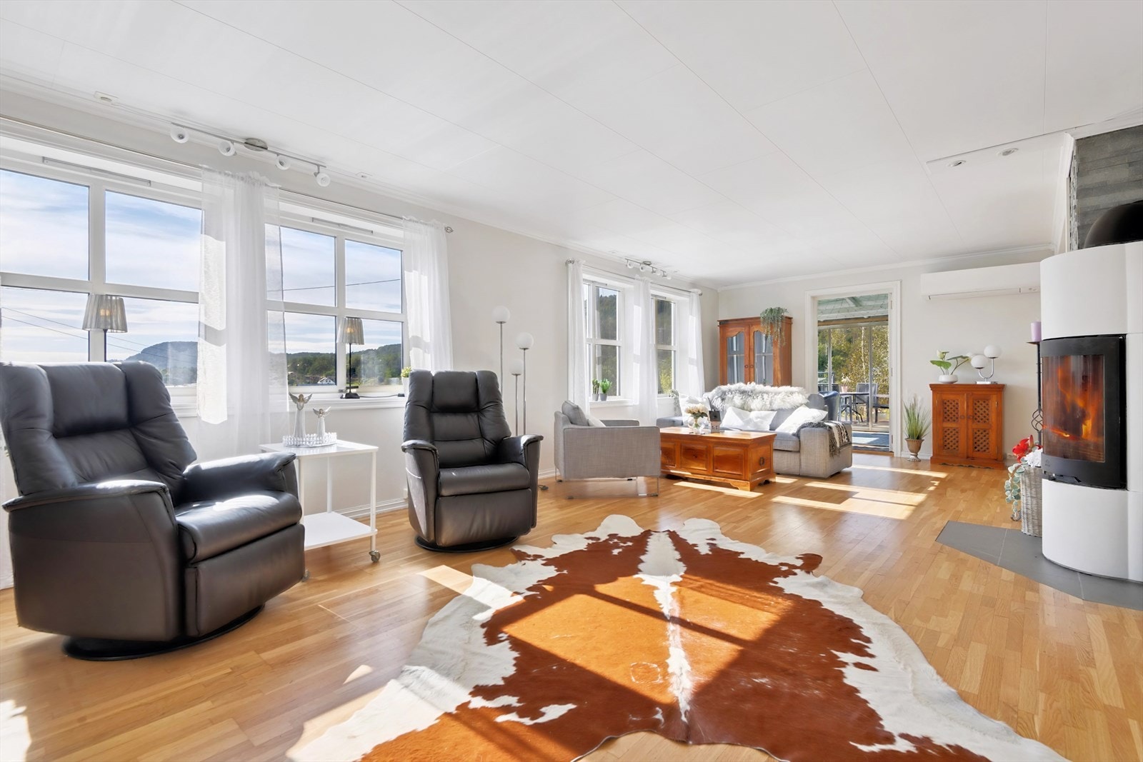 Stuene er åpen og lys, med store vindusflater og god plass til møblering Galleribilde