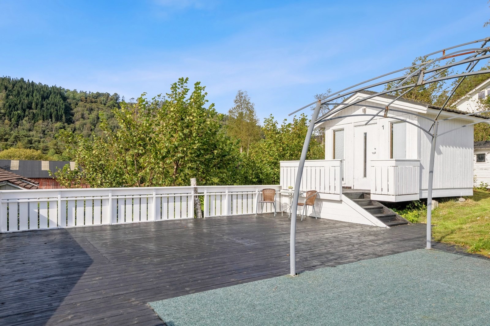 Ovenfor badstuen er det en stor terrasse med to småhytter bak Galleribilde