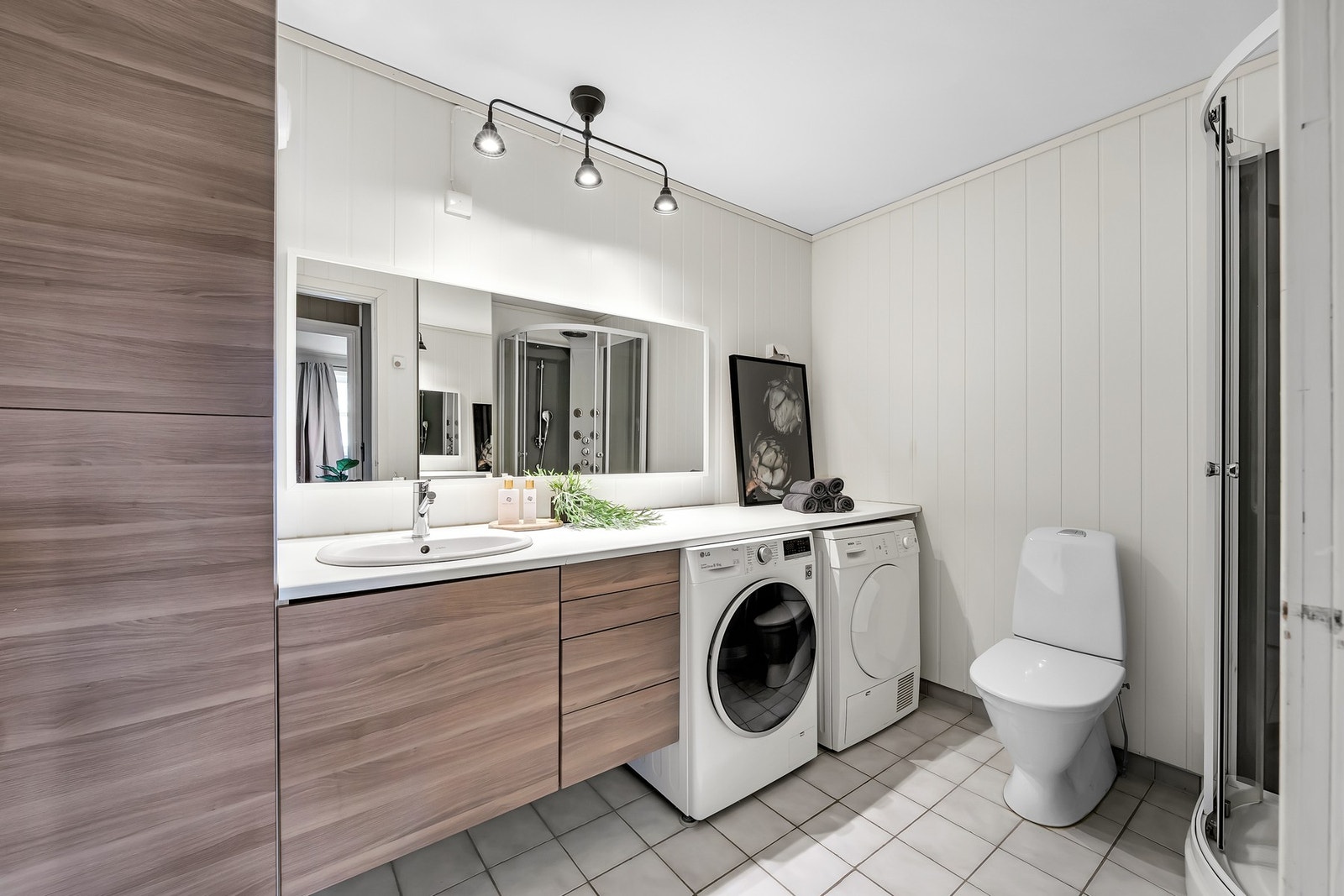 Flislagt bad med fin og praktisk baderomsinnredning. Galleribilde