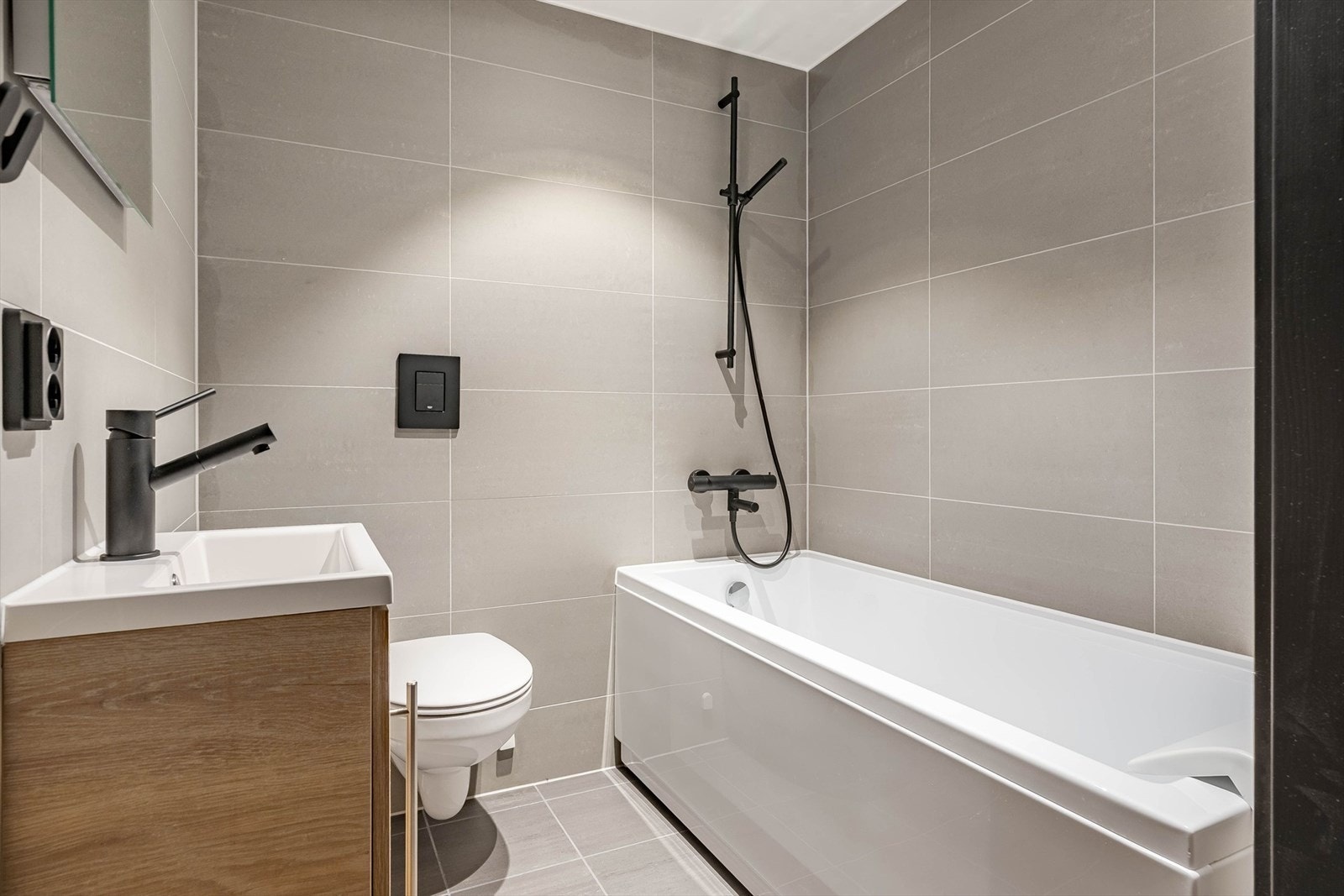 Delikat, flislagt bad med badekar Galleribilde