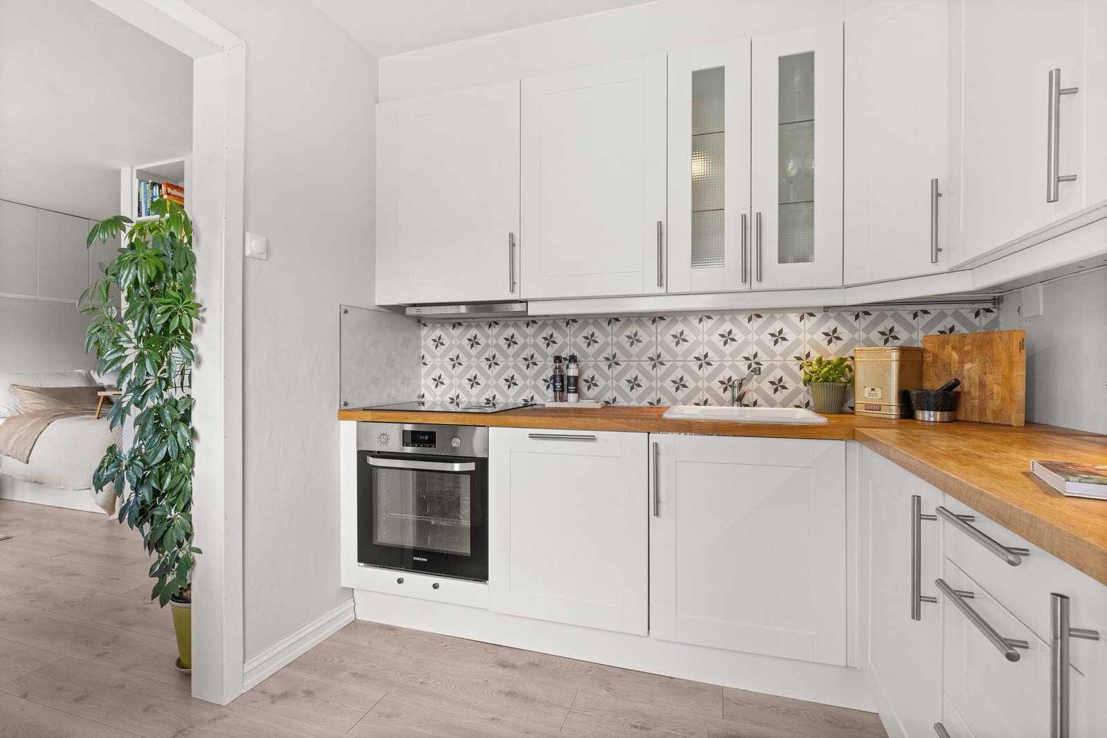 Praktisk utstyrt med nedfelt oppvaskkum i porselen, integrert oppvaskmaskin, stekeovn og induksjonstopp, samt frittstående kjøleskap med frysedel. Galleribilde