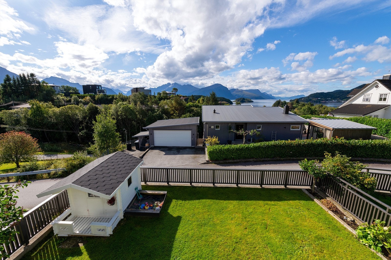 Utsikt fra skjermet inngjerdet hage med lekehytte Galleribilde