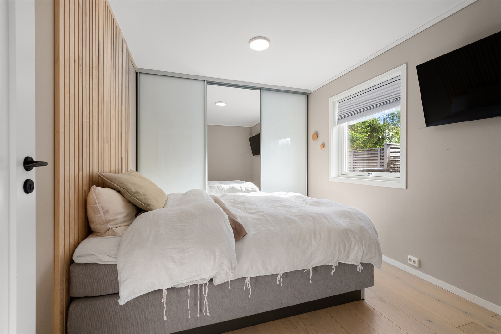 Lys og trivelig hovedsoverom med skyvedørsgarderobe Galleribilde