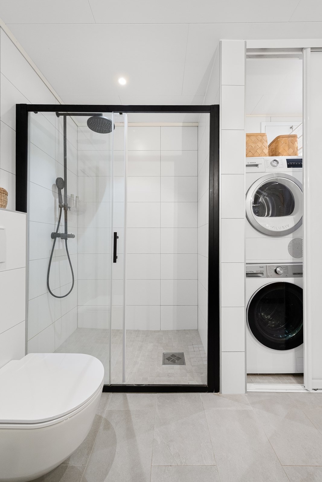 Det er skyvedører på badet til praktisk nisje med plass til vaskemaskin og tørketrommel. Varmtvannsbereder plassert i hjørnet her. Galleribilde