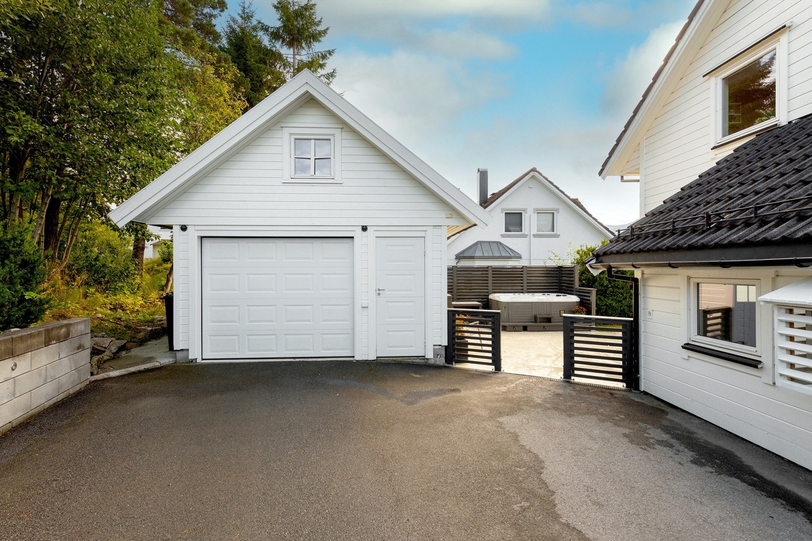 Asfaltert gårdsplass og garasje med leddport Galleribilde
