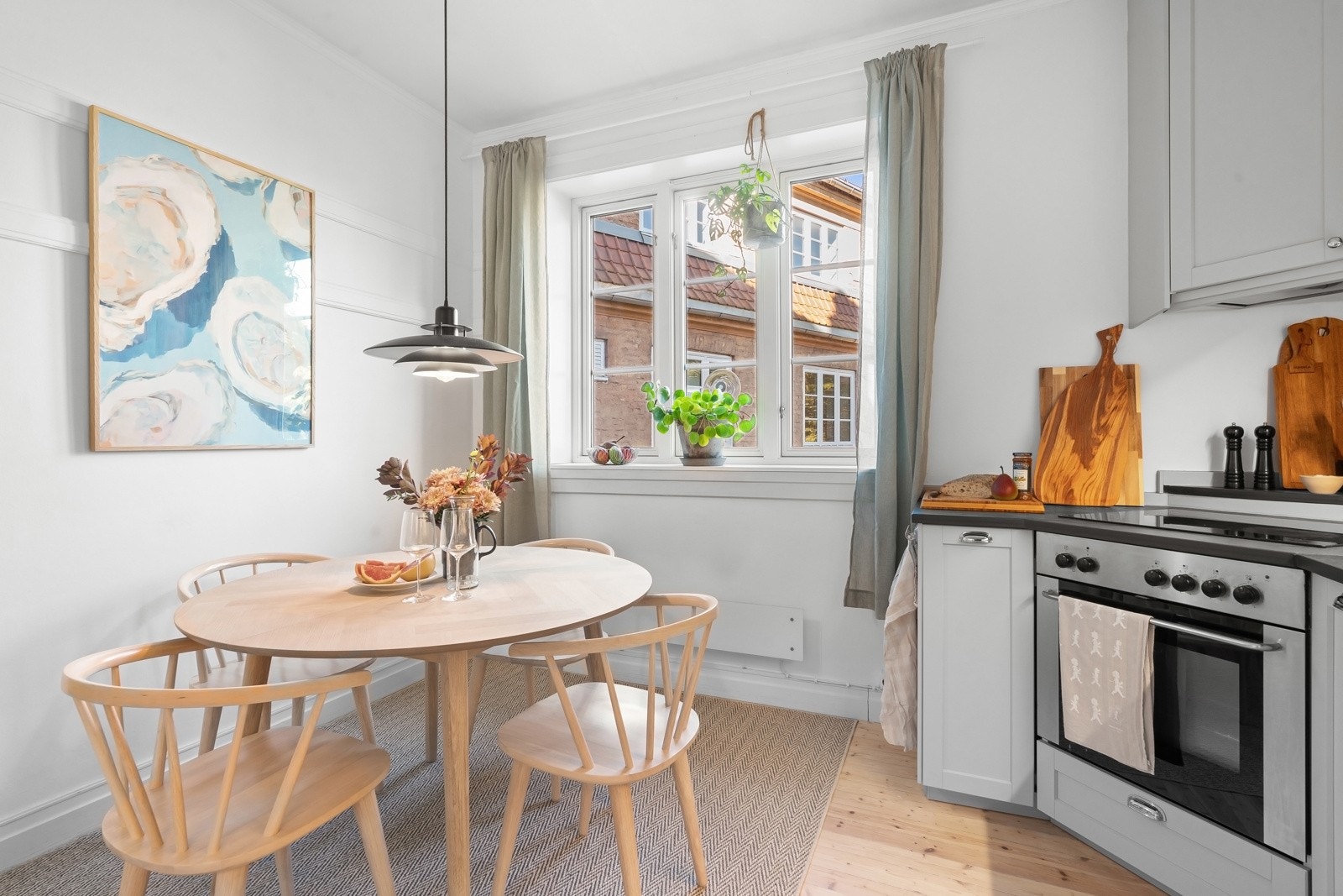 Naturlig avsatt plass til spisebord med utsikt mot hyggelig bakgård Galleribilde