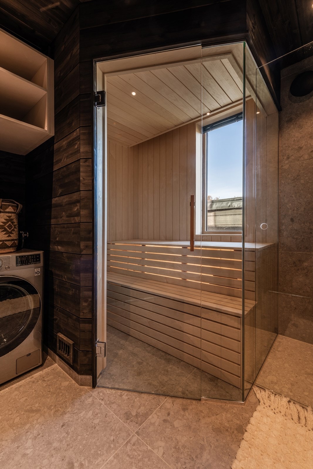 Her er det fliset gulv med elektriske varmekabler, veggene har fliser og panel/tømmer. Galleribilde