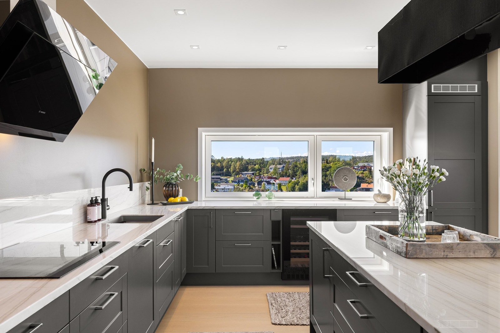 Vask og platetopp av 60 cm. bredde er praktisk plassert side om side, omgitt av arbeids- og avlastningsplass på meterlange marmorplater. Galleribilde