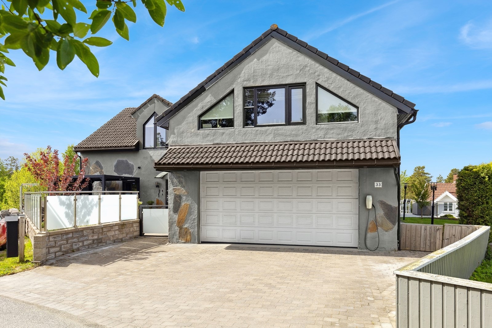 Boligen har gode parkeringsmuligheter med dobbelgarasje og romslig gårdsplass med belegningsstein - praktisk for både hverdag og gjester. Galleribilde