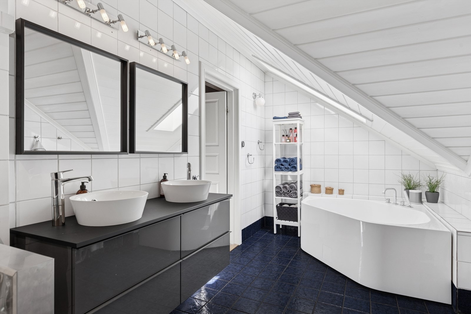 Lyst og innbydende baderom med fliser, praktisk innredning og mulighet for både dusj og badekar. Galleribilde