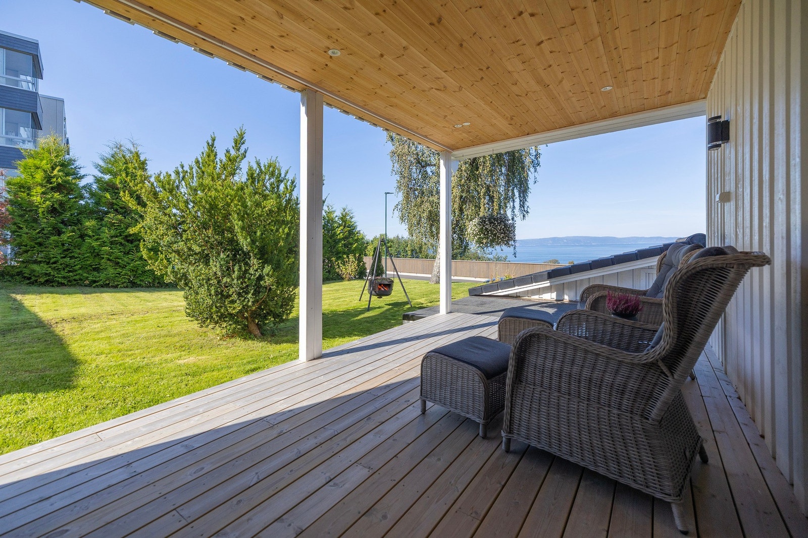 Fra stuen kommer man ut på en av boligens terrasser. Overbygg med spotter i himling. Her er det kveldsol frem til ca. kl. 23. Galleribilde