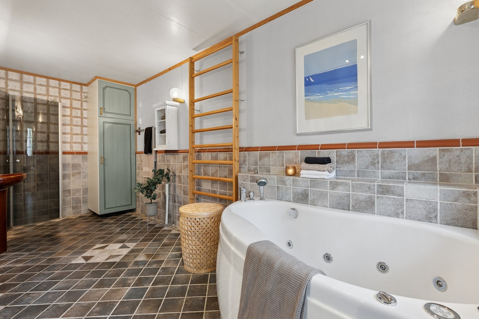 Eldre bad fra før 1997 med fliser på gulvet og tapet samt brystflis på vegg. Badet er utstyrt med servant, speil, belysning og badekar. Galleribilde