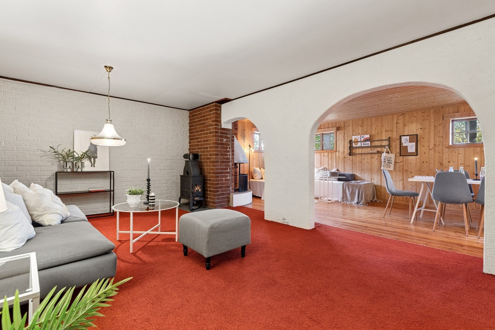 Peisestuen er en stor vinkelstue med teppe på gulvet i den ene delen og furugulv i den andre delen. Kjellervinduer står høyt oppe på veggen. Galleribilde