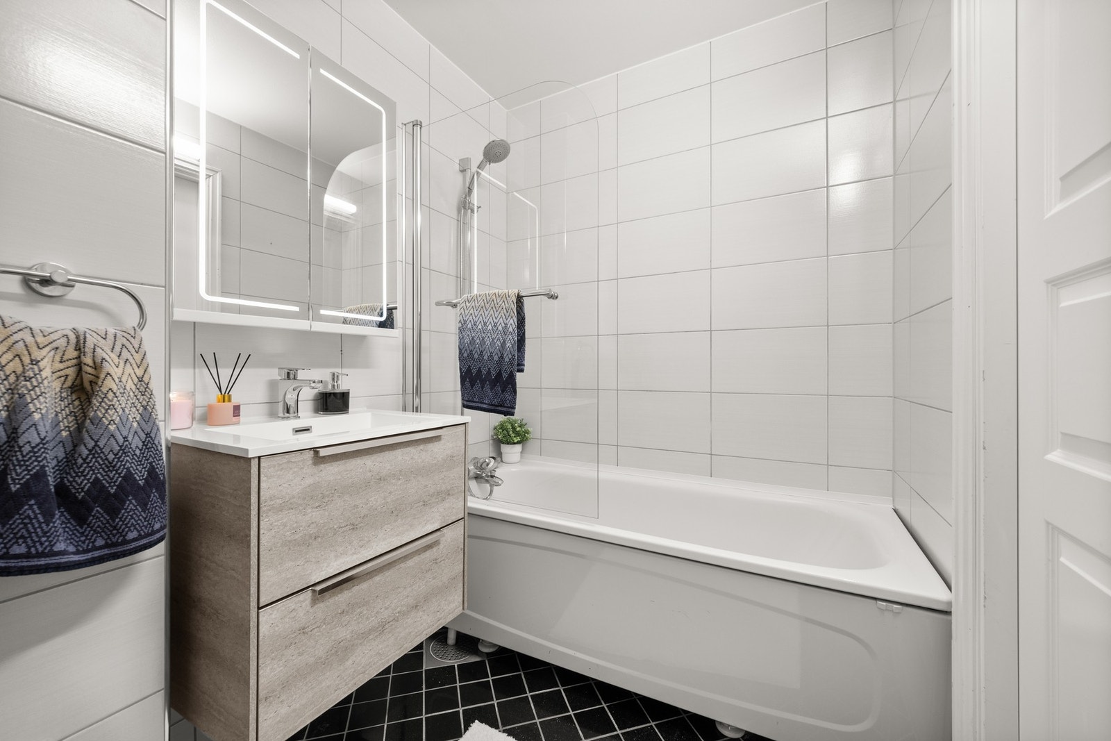 Leiligheten har et pent bad med flislagte overflater Galleribilde