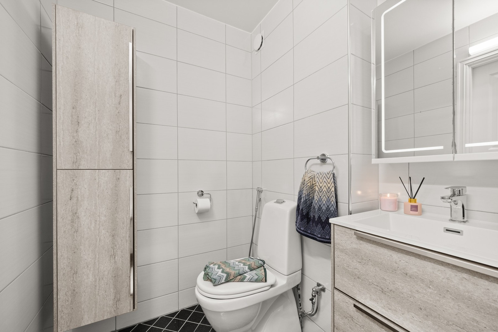 Badet inneholder: Servatseksjon, frittstående badekar, gulvmontert toalett og overskap med speilfronter og integrert lys Galleribilde