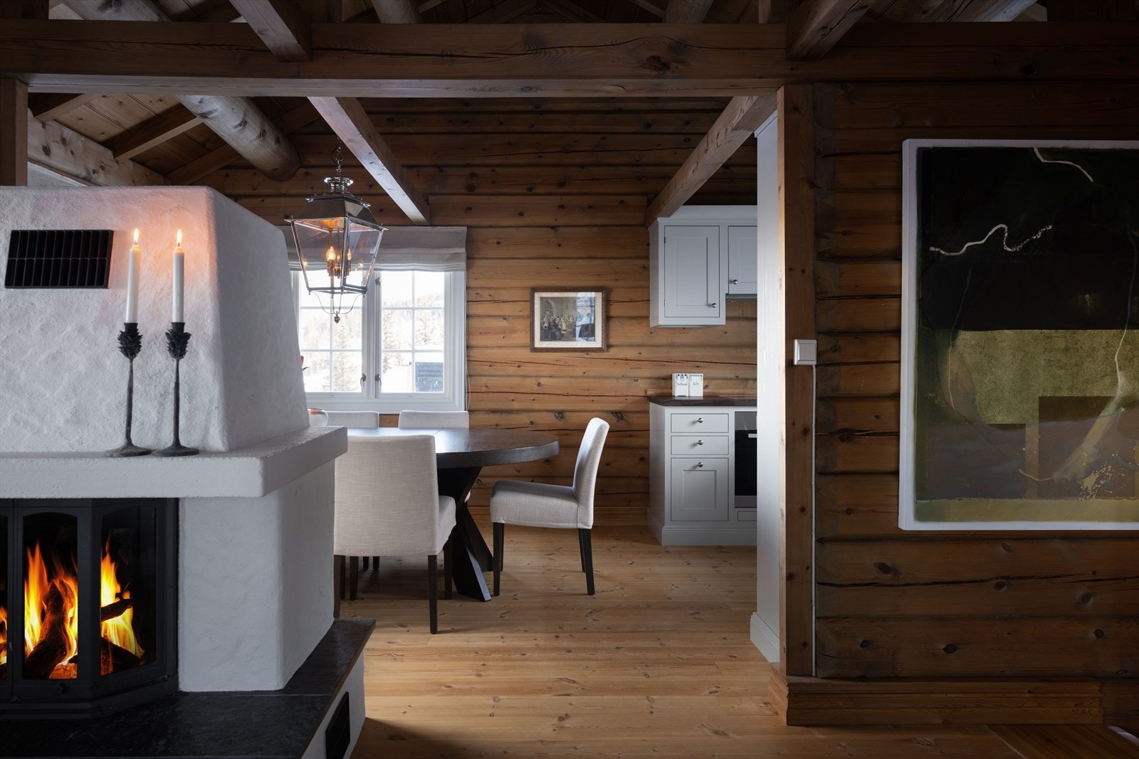 Kjøkken og spisestue er delvis adskilt fra stuen, delt av en koselig peis med innsats. Galleribilde