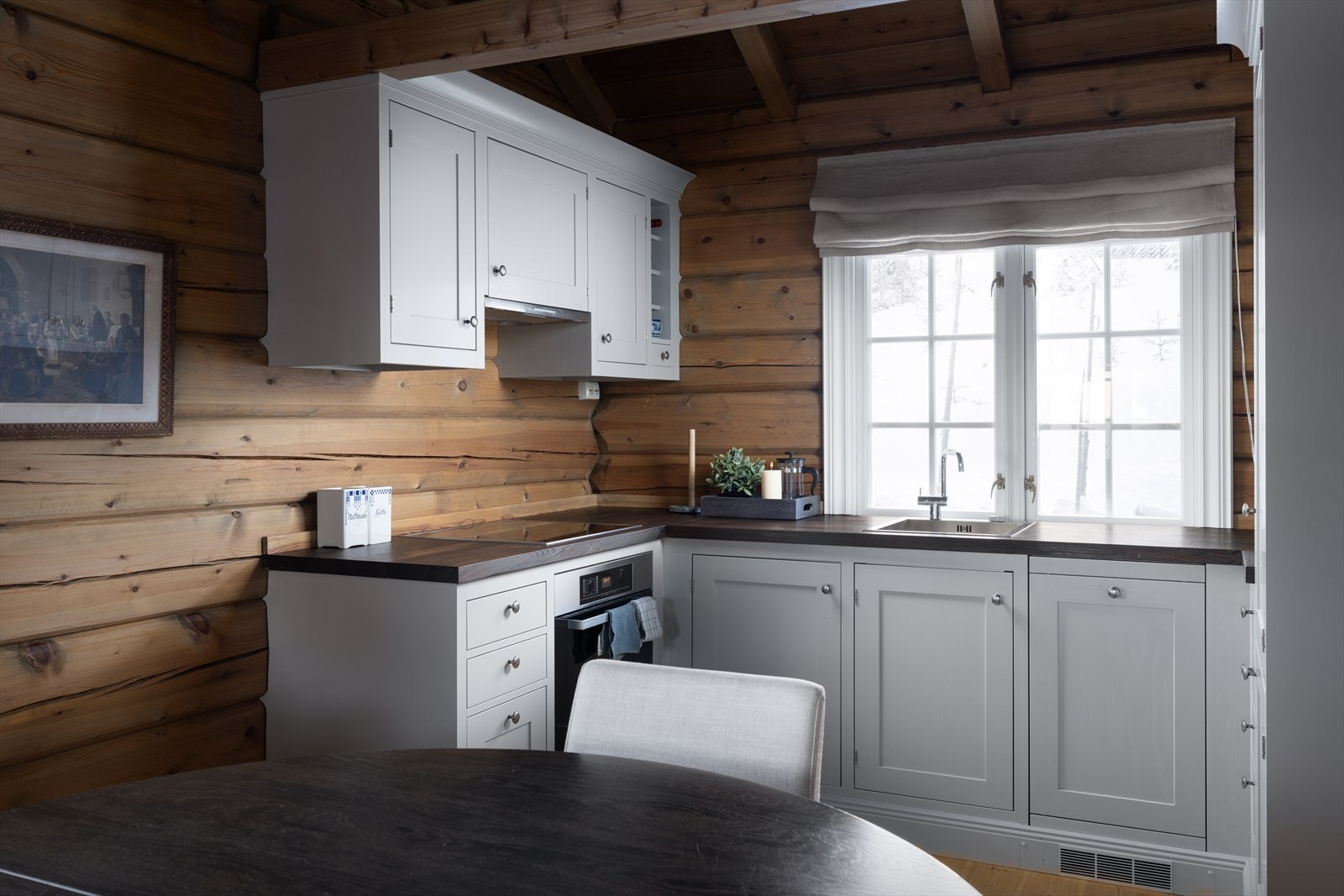 Nyere kjøkkeninnredning med heltre fronter og benkeplate, og i samme stil som i hovedhytta. Galleribilde