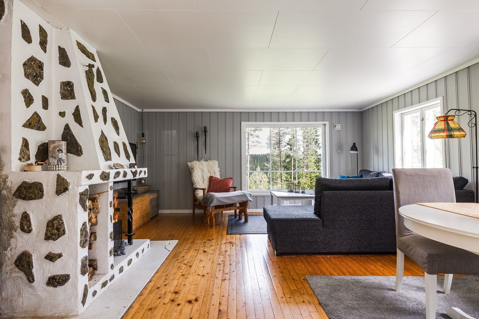 I stuen står det en eldre, åpen peis med naturstein. Galleribilde