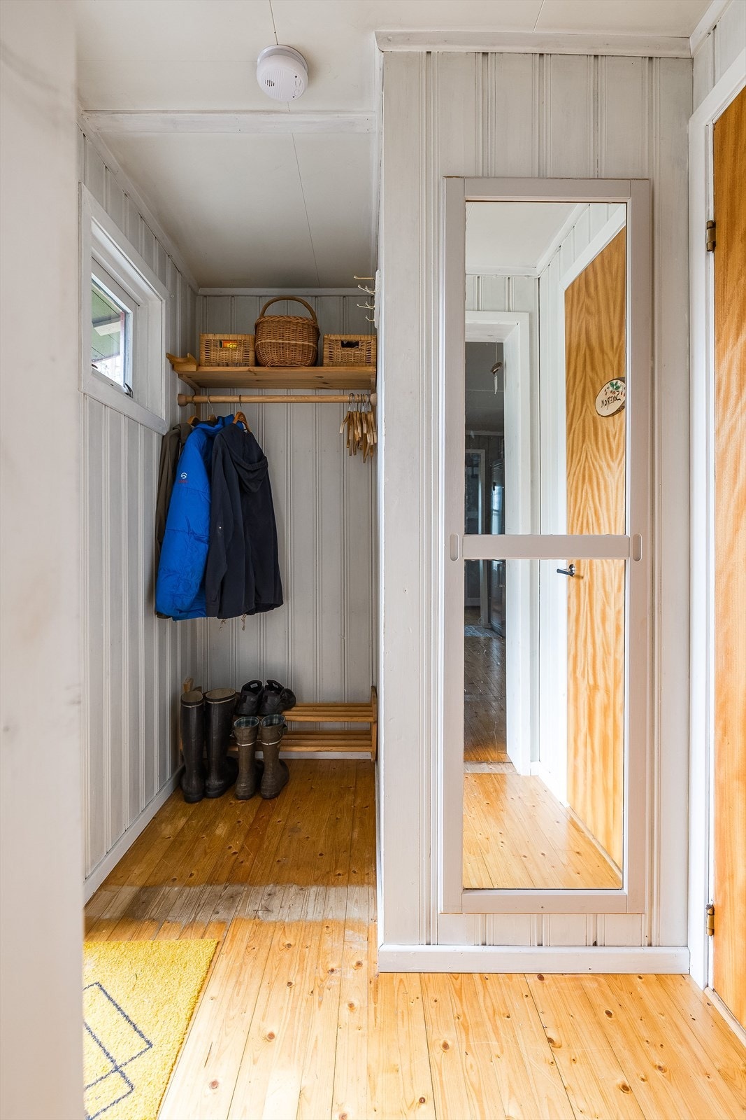 Velkommen inn! Du møtes av en lys gang med egnet plass for oppheng av tøy. I tilknytning til gangen ligger det et soverom, og det er åpen adkomst inn til kjøkkenet. Galleribilde