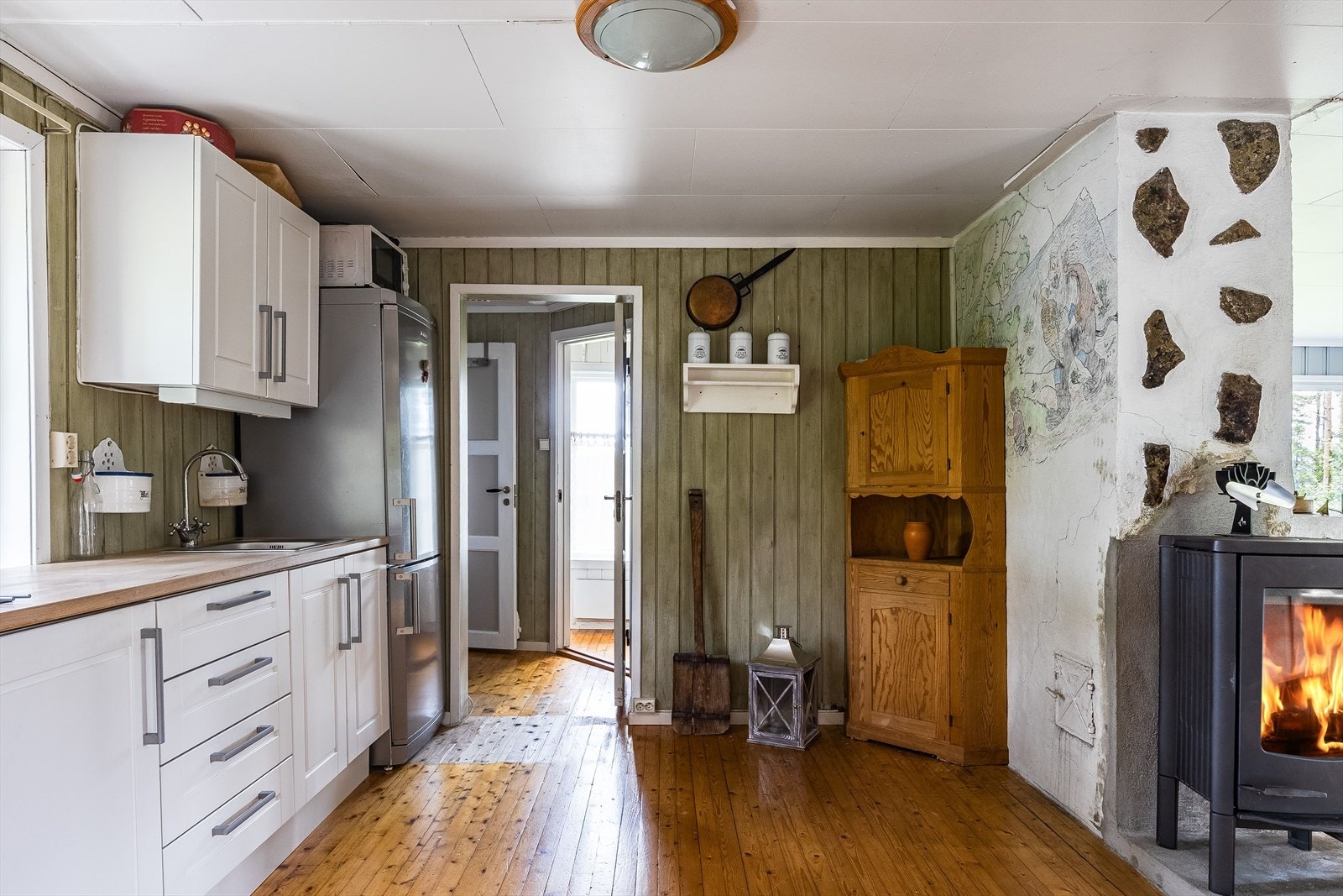 Kjøkkenet ligger fint til med lett adkomst til spisestue. En nyere peisovn med glassdør sørger for god varme på de kaldere dagene. Galleribilde