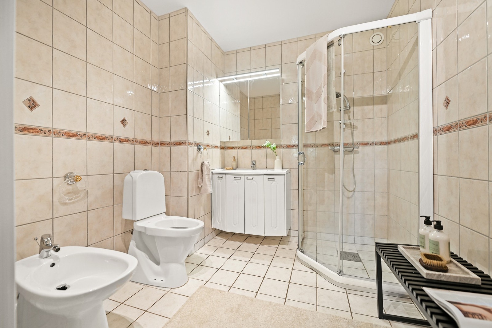 Badet er innredet med nedfelt servant, gulvfestet toalett, bidet og dusjhjørne. Galleribilde