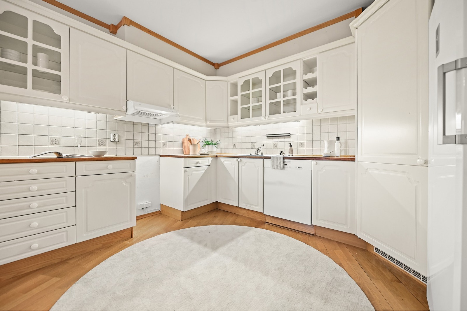 Kjøkkeninnredning er med profilerte fronter og heltre benkeplate. Plass til komfyr og fryseskap, integrert kjølehjørne og underbygget oppvaskmaskin. Galleribilde