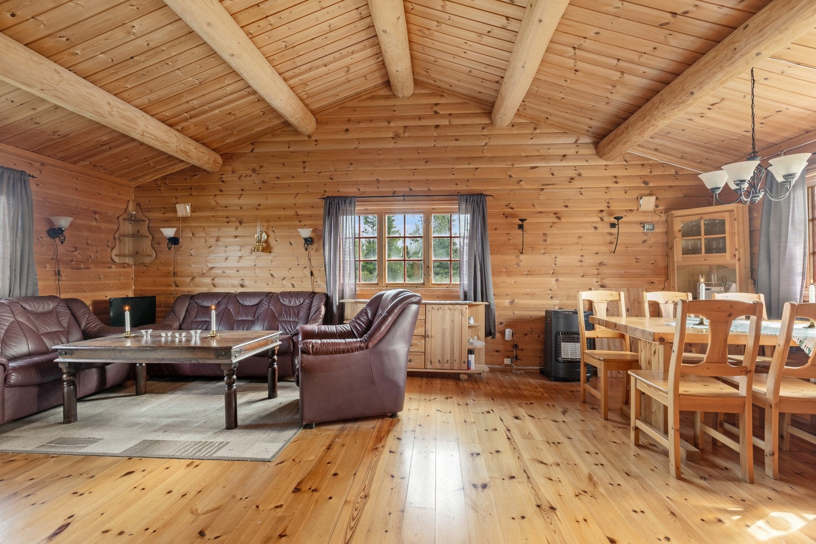 Hytta har en romslig stue med god takhøyde og fine og dekorative rundåser i taket. Galleribilde